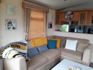 a living room with a couch and a table at Locatie Het Knooppunt Engelse Chalet in Nuis