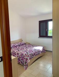 サンタンナ・アッレージにあるOrchidea Porto Pinoのベッドルーム(ベッド1台、窓付)