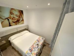 um pequeno quarto com uma cama com uma fotografia na parede em Marilyn em Roses