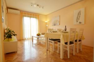a dining room with a white table and chairs at Bernardo Apartment in Rovinj