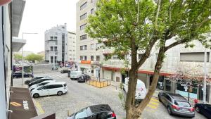 a city street with cars parked in a parking lot at MyTrip Porto in Matosinhos