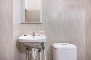 W łazience znajduje się umywalka, toaleta i lustro. w obiekcie OYO 1226 Al Abror Homestay w mieście Yogyakarta