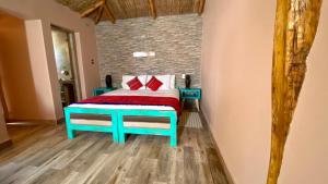 ein Schlafzimmer mit einem Bett und einer Ziegelwand in der Unterkunft Ickota B&B in San Pedro de Atacama