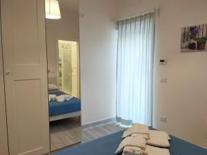 een slaapkamer met een spiegel en een bed in een kamer bij Botteghelle Home in Casalnuovo di Napoli