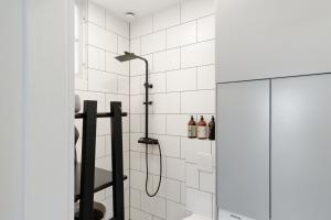 eine Dusche im Bad mit weißen Fliesen in der Unterkunft Beautifully renovated lakeside red cottage in Salo + 18 Fotos