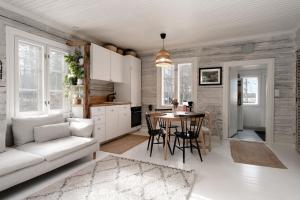 ein Wohnzimmer mit einem Sofa und einem Tisch in der Unterkunft Beautifully renovated lakeside red cottage in Salo