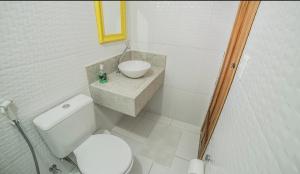 a bathroom with a white toilet and a sink at Pousada Vivenda Verde in Pirenópolis