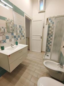 a bathroom with a sink and a toilet and a shower at Botteghelle Home in Casalnuovo di Napoli