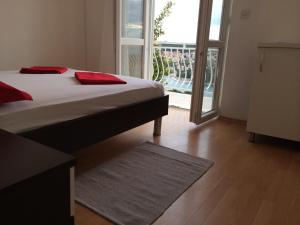 a bedroom with a bed and a view of a balcony at Rooms Tomaš in Dubrovnik