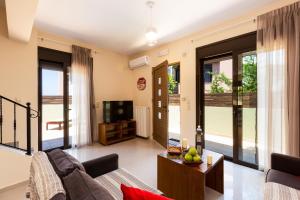 a living room with a couch and a tv at Villa Dafni in Pangalochori