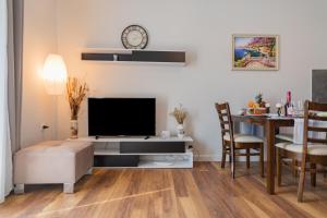 uma sala de estar com uma televisão e uma mesa com uma sala de jantar em Jordi apartment em Corfu Town