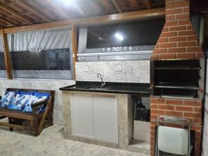 a kitchen with a sink and a stove in a room at Chale do Caruso in Mairinque