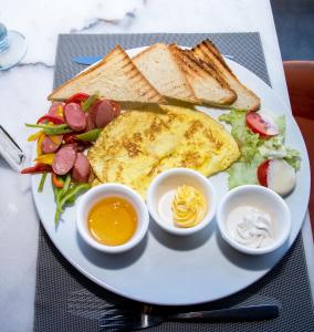 un plato de desayuno con huevos, pan y tostadas en Marvel Stone Hotel, en El Cairo