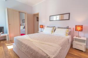 um quarto com uma grande cama branca e um espelho em Jordi apartment em Corfu Town