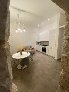a living room with a table and a kitchen at Casa Maria in Siracusa