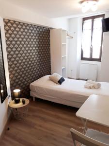 una habitación con 2 camas y una mesa en una habitación en Hotel renaissance martigues, en Martigues