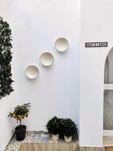 een witte muur met drie ronde spiegels bij Casa Kalameta in Estepona