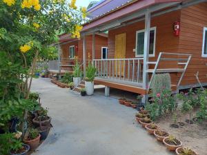 a porch of a house with potted plants on it at Stay Ban Posai with Pool in Prakhon Chai