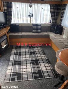 a living room with a couch and a tv at Beautiful 6 birth caravan in Ingoldmells