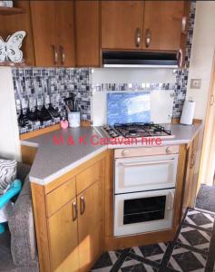a kitchen with a white stove top oven at Beautiful 6 birth caravan in Ingoldmells