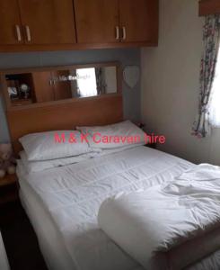 a bedroom with a large white bed in a room at Beautiful 6 birth caravan in Ingoldmells