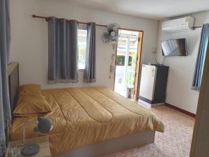 1 dormitorio con 1 cama, ventana y nevera en Stay Ban Posai with Pool, en Prakhon Chai