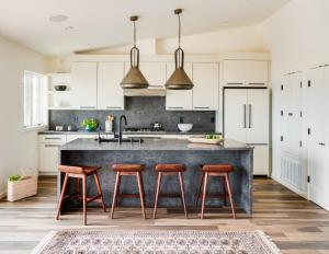 a kitchen with white cabinets and a large island with stools at A little piece of heaven... in Half Moon Bay