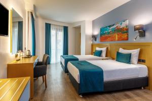 イスタンブールにあるUrban Hotel Bomontiのベッド2台とデスクが備わるホテルルームです。