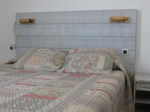 a bed with a headboard and two pillows on it at Le Parasol in Ars-en-Ré