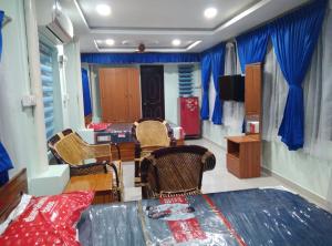 una sala da pranzo con tavolo, sedie e tende blu di Elim luxury suite a Tarangambādi
