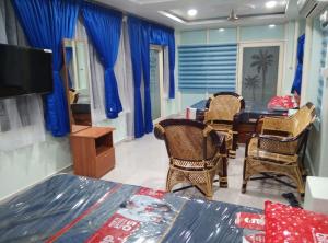 a room with a table and chairs and a television at Elim luxury suite in Tarangambādi