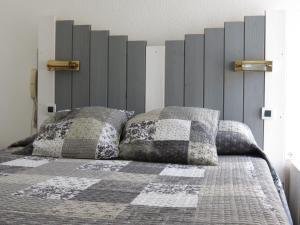 um quarto com uma cama com duas almofadas em Le Parasol em Ars-en-Ré