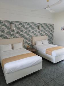 - 2 lits dans une chambre avec une fresque murale dans l'établissement Hotel Gran Palmeiras, à Chachalacas
