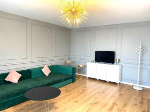 a living room with a green couch and a television at Velvet Home in Timişoara