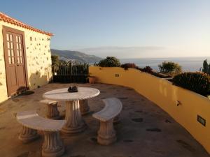 patio ze stołem i 2 ławkami w obiekcie Los Frailes w mieście Breña Baja
