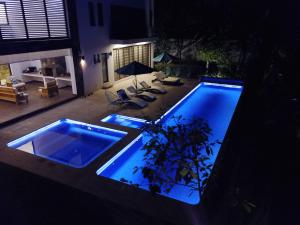 een groot zwembad in een tuin 's nachts bij Casa Huitzil - La mejor casa de Malinalco con alberca y jacuzzi climatizados in Malinalco