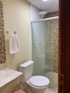 a bathroom with a toilet and a glass shower at Casinhas da Vila - Itacaré in Itacaré
