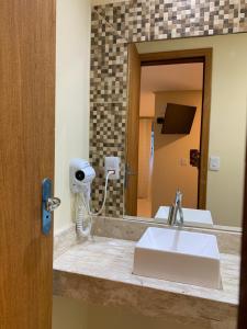a bathroom counter with a sink and a mirror at Casinhas da Vila - Itacaré in Itacaré +1 photo