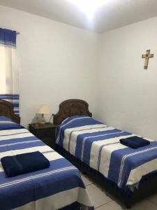 サンタ・クルス・ウアトゥルコにあるDepartamento la crucecita, con aire acondicionado, excelente ubicación, en segunda plantaのベッドルーム1室(ベッド2台付)が備わります。