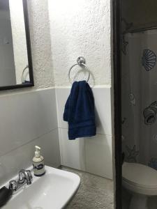 サンタ・クルス・ウアトゥルコにあるDepartamento la crucecita, con aire acondicionado, excelente ubicación, en segunda plantaのバスルーム(シンク、青いタオル付) +5枚の写真