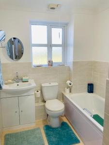 a bathroom with a toilet and a tub and a sink at Stunning Seafront House with garden and private parking in Eastbourne +78 photos