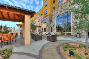 Staybridge Suites Lubbock South, an IHG Hotel في لوبوك: فناء فيه كراسي وطاولات امام مبنى