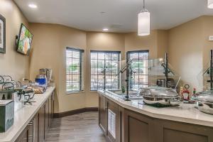 a large kitchen with a counter with many dishes at Staybridge Suites Lubbock South by IHG in Lubbock