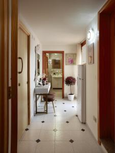 a hallway with a kitchen with a table and a refrigerator at Palazzo Stapane in Santa Maria al Bagno +77 photos