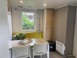 eine Küche mit einem Tisch und Stühlen sowie einem Fenster in der Unterkunft Neat chalet with microwave Antwerp at 39 km in Rijkevorsel