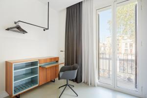 a living room with a window and a chair at Sonder La Casa Del Sol in Barcelona