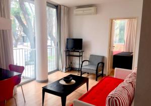 a living room with a red couch and a table at Apartamentos Libertador, Martinez in Martínez +16 photos