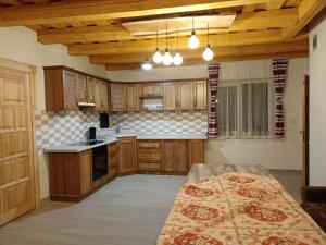 a large kitchen with wooden cabinets and a table at Пасторальний дім імені Владики Мілана in Bohdan
