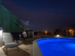a swimming pool on the roof of a building at night at Lux Vila Aleksandar in Sremska Kamenica