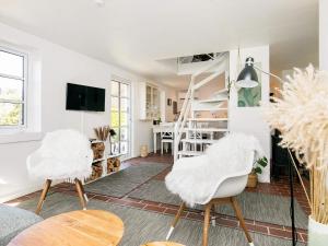 een woonkamer met 2 witte stoelen en een trap bij 4 person holiday home in Skagen in Skagen